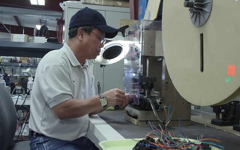 an employee works on cables for cable assembly and electronic enclosure