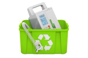 Green recycling bin with an infusion pump placed inside.