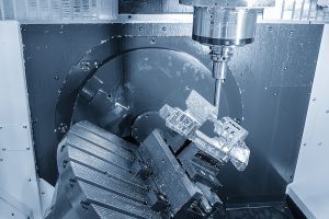 Close up of a machine cutting an aerospace part in an aerospace manufacturing plant. 