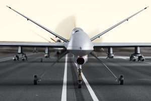 Military armed UAV drone preparing for takeoff on a runway.